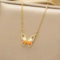 Macro detail of gold butterfly pendant with orange and white teardrop stones and diamonds - Gold Orange Butterfly Style