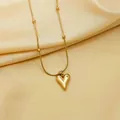 Detail of gold heart pendant necklace on silk featuring round beads and sleek snake chain - Necklace / Gold