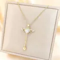 Golden heart necklace with movable angel wings and tassel drop on a silk display - White Gemstone/Adjustable / Gold
