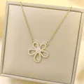 Detailed macro view of a sparkling gold six-petal flower pendant with white zircon inlay - Necklace / Gold