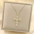 Golden copper cross necklace with micro-pave oval clear zircons on a satin jewelry box - Gold Base White Gemstone Style / Gold-White