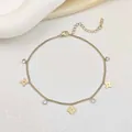 Detail of gold clover bracelet with zircons and S.Steel stamp on a white satin background - Gold