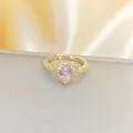 Eleganter goldener Herzring mit rosa Edelstein und Zirkon auf Seidenhintergrund - Goldener Ring Rosa Herz (C195)