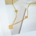 Elegant gold titanium clover necklace with white zircon crystals on a white book base - Gold Necklace