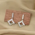 Geometric silver titanium earrings with zircons and textured finish on neutral fabric - Silver Stud Earrings