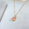 Detail of pink cat-eye stone and white zircon pendant on a gold beaded chain - Gold Pink