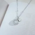 Elegant cat eye stone pendant necklace with silver chain on an open book background - Silver White