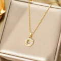 Detailed close-up of golden interlocking rings pendant with zircon micro-pave setting - Planet Style
