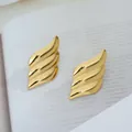 Détail macro de boucles d'oreilles vagues dorées à trois couches, finition miroir - Vague d'Aile (C670)