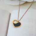 Close-up of heart-shaped black enamel pendant necklace on rose gold steel chain - Hollow Heart Style (S8150)