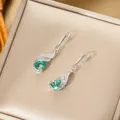 Elegant peacock drop earrings with green teardrop stones in a luxury jewelry box - Silver Stud Earrings