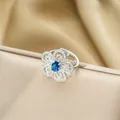Elegante anello a fiore di iris con zaffiro blu e petali di cristallo color argento - Anello d'Argento