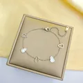 Détail du bracelet en acier titane argenté avec pendentifs gourde sur satin - Bracelet Wulu Blanc Argenté