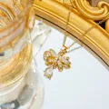 Makroaufnahme der goldenen Schleifen-Halskette mit Zirkonia und Wassertropfen-Anhänger - Goldene Schleife Halskette