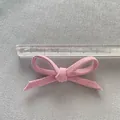 Detailed view of a 6cm pink fabric bow with cotton texture measured by a scale - Pink