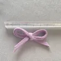 Detail showing a 5.5cm wide purple fabric bow accessory measured with a transparent ruler - Light Purple