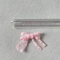 Vue détaillée d'un petit nœud en satin rose de 3 cm avec texture tissée sur lin - Rose