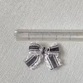 Gros plan d'un mini nœud rayé noir et blanc de 3cm avec bords ondulés pour bijoux de cheveux - Rayures Noires et Blanches