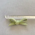 Dettaglio di un fiocco in tessuto fatto a mano verde erba con trama intrecciata definita - Stile Verde Erba (3)