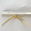 Detailansicht einer 7,5cm goldenen PU-Leder-Schleife für DIY-Deko mit einem Maßstab - Medium Stil / Gold