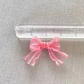 Dettaglio di un mini fiocco in organza rosa da 3cm per accessori capelli fai-da-te - Rosa chiaro