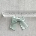 Macro detail of a 3.5cm handmade satin ribbon bow used for DIY crafts and hair accessories - Light Blue