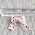 Detailed close-up of a 2.5cm pink polka dot ribbon bow with measurement scale - Pink With Black Dots (7)