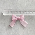 Detail showing a 2.8cm handmade pink satin ribbon bow accessory for DIY craft hair clips - Pink