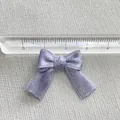Close-up of a 2.5cm lavender glitter ribbon bow with a ruler showing the exact size - Light Purple Glitter