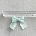 Detail of light blue satin ribbon bow with ruler showing 3cm width for DIY crafts - Cyan