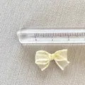 Detailed close-up of 3cm mini beige mesh bow showing texture and ruler for size - Cream