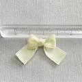 Top view of a 3.2cm cream satin bow accessory measured with a transparent ruler - Cream