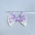 Purple satin bow with heart patterns and rhinestones shown on a measuring ruler - Purple Heart Design (1)