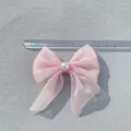 Accesorio de lazo rosa brillante con perla blanca sobre fondo de tela gris claro - Rosa Sakura
