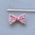 Vista dettagliata di un fiocco in pizzo rosa da 6cm con strass per capelli e decori - Rosa