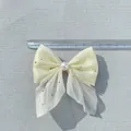 Detalle del lazo de malla de doble capa con perlas y strass mostrando el tamaño 8,5cm - Amarillo claro