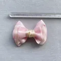 Detailopname van een 7 cm roze en crème satijnen strik met meetlat voor de juiste afmeting - Roze Satijn Meerlaags (10)