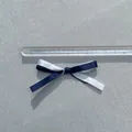Detailansicht einer 5,5cm zwelagigen Satin-Schleife in Weiß und Marineblau für Haarschmuck - Doppellagige Schleife / Marineblau/Weiß