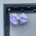 Purple plaid fabric bow with white lace trim and center pearl, measured on a scale - Purple Plaid