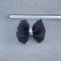 Detail view of a 9cm handmade black fabric bow with polka dot center and size ruler - Black Shimmer Polka Dot Ribbon Bow (5)