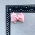 Close-up of 80mm baby pink grosgrain ribbon bow with a scale showing size and texture - Baby Pink Layered Grosgrain Bow (5)