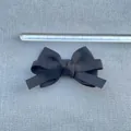 Detailed view of an 8.5cm black grosgrain ribbon bow with a ruler for scale measurements - Pure Black Grosgrain Layered Bow (6)