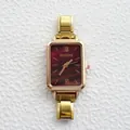 Makroaufnahme des goldenen Gehäuses und weinroten Zifferblatts mit römischen Ziffern - Violettes Wellenzifferblatt Goldenes Armband (4)