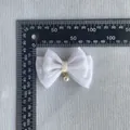 Detail of white glitter fabric bow with pearl pendant and yellow ribbon center - Pure White (5)