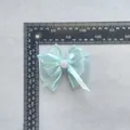 Detailansicht der hellblauen Organza Schleife mit kleiner Rose und Lineal zur Messung - Hellblau