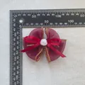 Detailansicht einer burgunderroten Organza-Schleife mit weißer Rosenperle und Maßstab - Burgunderrot