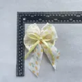 Pince à cheveux nceud en dentelle blanche avec rubans à cœurs et perle centrale - Style Cœur Jaune (4)