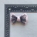 Dettaglio fiocco rosa glitterato con pizzo nero e righello per misurazione delle dimensioni - fiocco doppio / Rosa Glitter Pizzo Nero