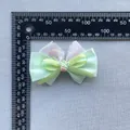 Detailed view of floral bow hair accessory with strawberry charm on a measurement grid - Light Green Strawberry Style (6)