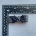 Detail view of a handmade tweed bow hair clip with black ribbon against a scale ruler - Tweed Satin Patchwork Style (6)